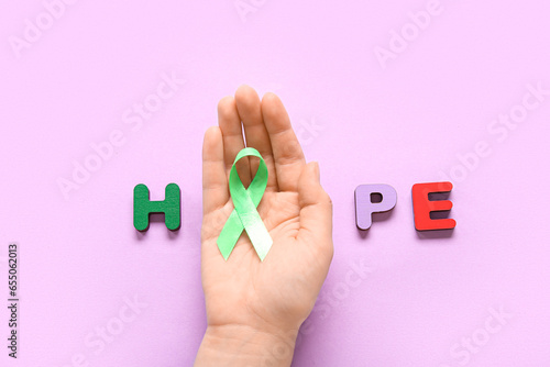 Female hand with green awar...
