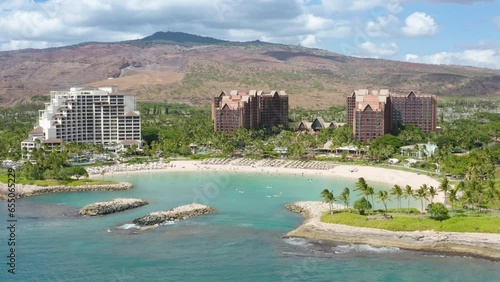 Drone shot family hotel with scenic blue lagoon view. Cinematic shot on Ko Olina resorts on Oahu island Hawaii USA tourism. Palm trees exotic travel paradise 4K. Aerial view of luxury beachfront hotel photo