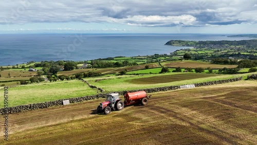 Aerial Video of Massey Ferguson 390T Tractor and Abbey Tanker spreading manure slurry in a field on a farm in UK  09-09-23 photo