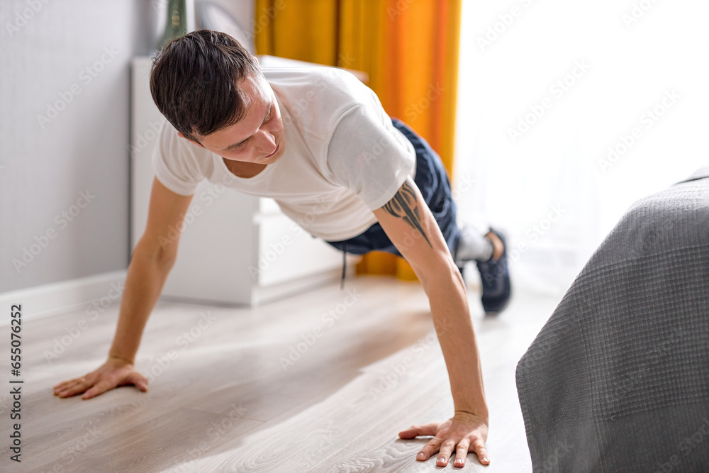 active handsome Caucasian guy with leg prosthesis artificial legs engaged in sport, doing exercises at home alone, indoors. Disabled sport and healthy lifestyle, motivation, hope concept. active handsome Caucasian guy with leg prosthesis artificial legs engaged in sport, doing exercises at home alone, indoors. Disabled sport and healthy lifestyle, motivation, hope concept.