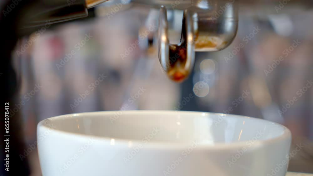 coffee pouring from dual pipe coffee machine into a white glass xteme