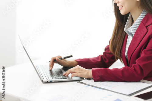Asian people independent investment consultant captured in her element at office, donning vibrant red business suit. Her poised demeanor epitomizes blend of tradition modernity in today finance world