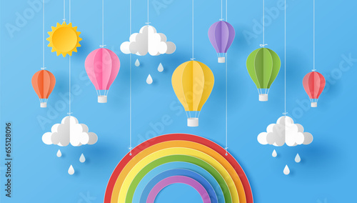 Paper cut style of sun, clouds, rain drops and hot air balloons with rainbow on blue sky. Summer background.  Vector illustration