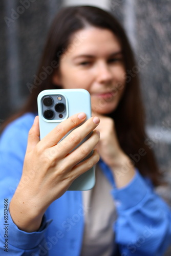 young woman makes selfie, video call with mobile phone