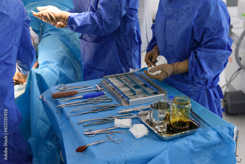 Surgical instruments in the operating room. Orthopedics and traumatology. Scalpel, hooks, chisel, impactor, osteotomes, bone hammer, screwdrivers, forceps. Drill, cutters and extractors on the table.
