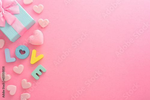 Gift box and LOVE lettering on a pink white background