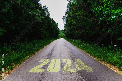 Scenic road with number2024 through summer trees.New year 2024 travel concept. photo