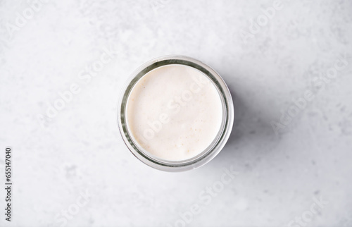 Tableau sur toile Pumpkin spices coffee creamer in a glass on a white background