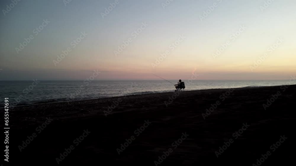 Fisherman on beach at dusk panning left and flying right Fisherman on beach at dusk panning left and flying right