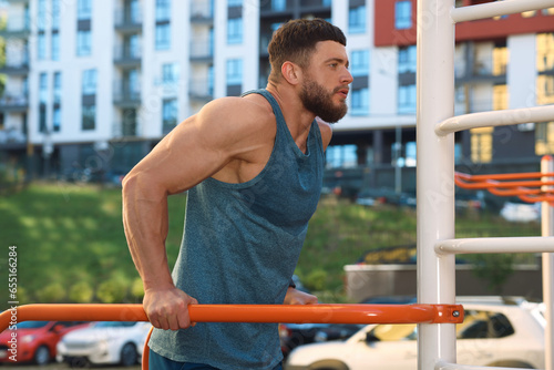 Man training on parallel bars at outdoor gym