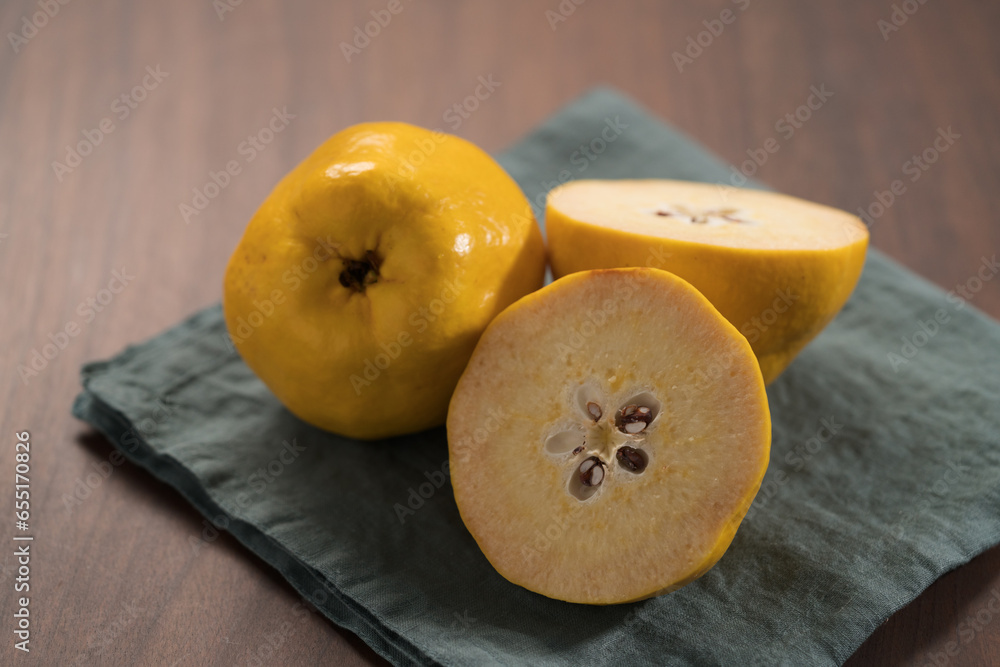 Two ripe quince fruit on wood table