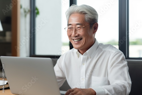 Senior asian man using laptop. AI Generated.