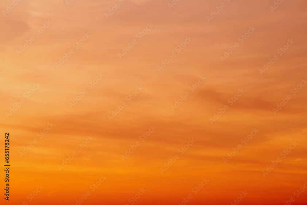 Obraz premium The colorful clouds against the orange sky create a breathtaking landscape.