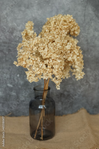 Dried flowers are on the table in a glass jar. tinting