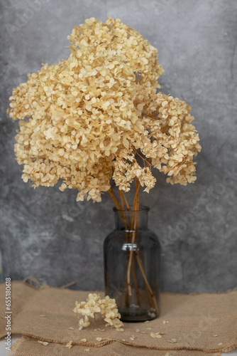 Dried flowers are on the table in a glass jar. tinting