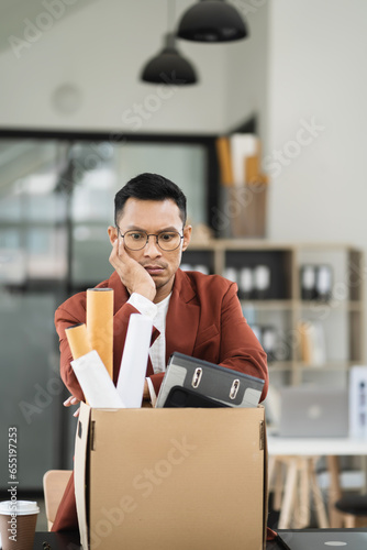 Concept business failure and unemployment problem, stress businessman packing up in office.