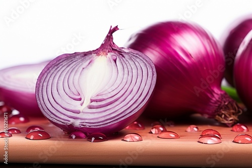 Vivid close up displays red onion slices and a whole one on wood