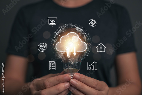A light bulb that shines in the hand of a businessman. One idea for transmitting business information using cloud technology. Ideas from searching for economic data for marketing.
