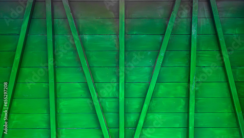 Green painted rustic wooden fence with messy paintwork