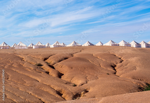 Morocco, desertic landscape in Agafay near Marrakech. Tents from the desert Camp in the background
