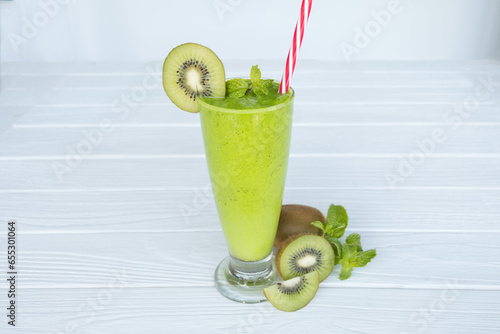 Kiwi yogurt fruit juice smoothie and green kiwi juice drink healthy, delicious taste in a glass for weight loss on a white wooden background.