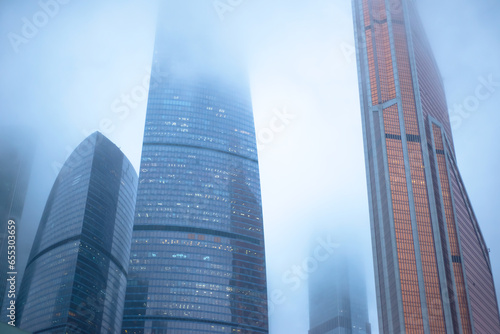 Skyscrapers rise into the foggy cloudy sky. Moscow City.