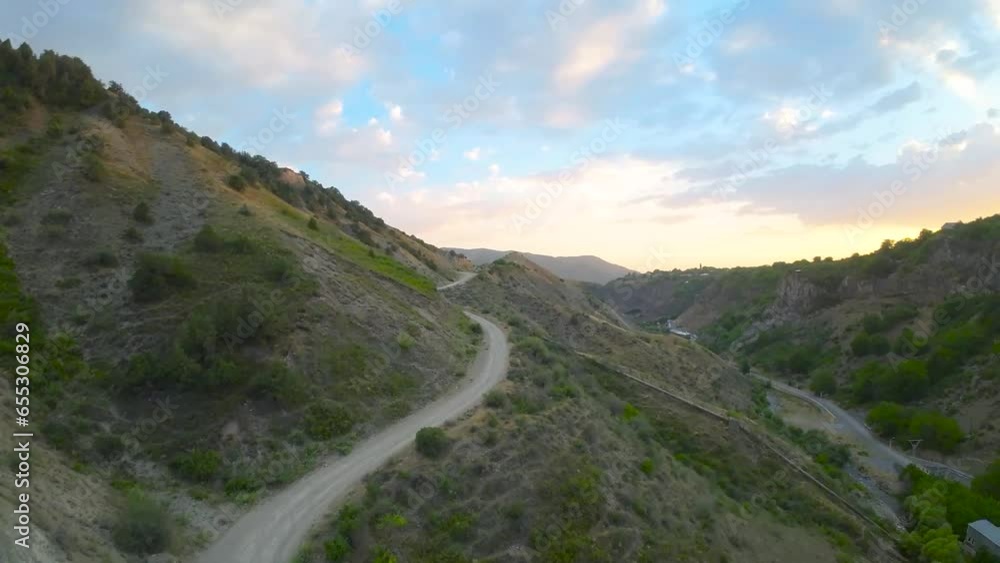 Drone soars above mountainous terrain, capturing winding roads and expansive grasslands, offering a breathtaking aerial view of the majestic landscape Drone soars above mountainous terrain, capturing winding roads and expansive grasslands, offering a breathtaking aerial view of the majestic landscape