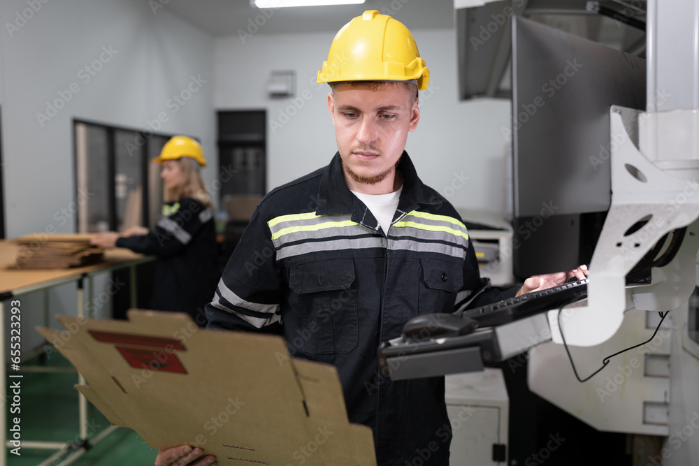 Technician caucasian man use computer control print machine and team working background at office Technician caucasian man use computer control print machine and team working background at office