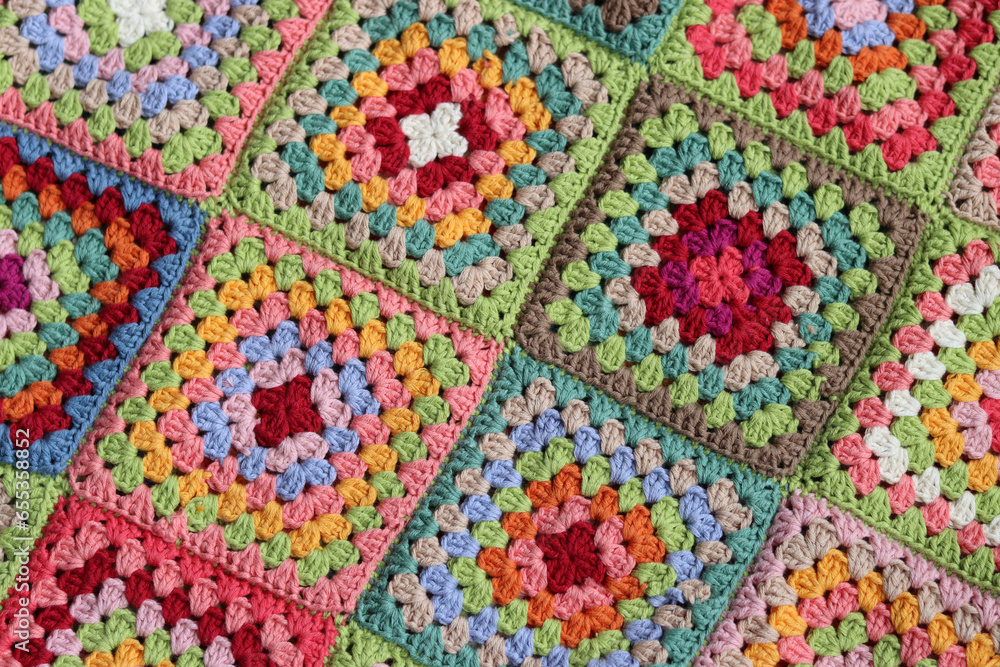 Colorful granny squares Crochet pattern close up photo. Beautiful ornament made of organic cotton yarn. Hobbies and leisure concept. 