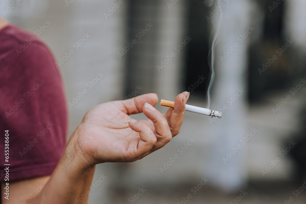 Cigarette, cigar with smoke in the hands of an elderly woman, a pensioner, a smoker. Photography, close-up portrait, smoking concept. Cigarette, cigar with smoke in the hands of an elderly woman, a pensioner, a smoker. Photography, close-up portrait, smoking concept.