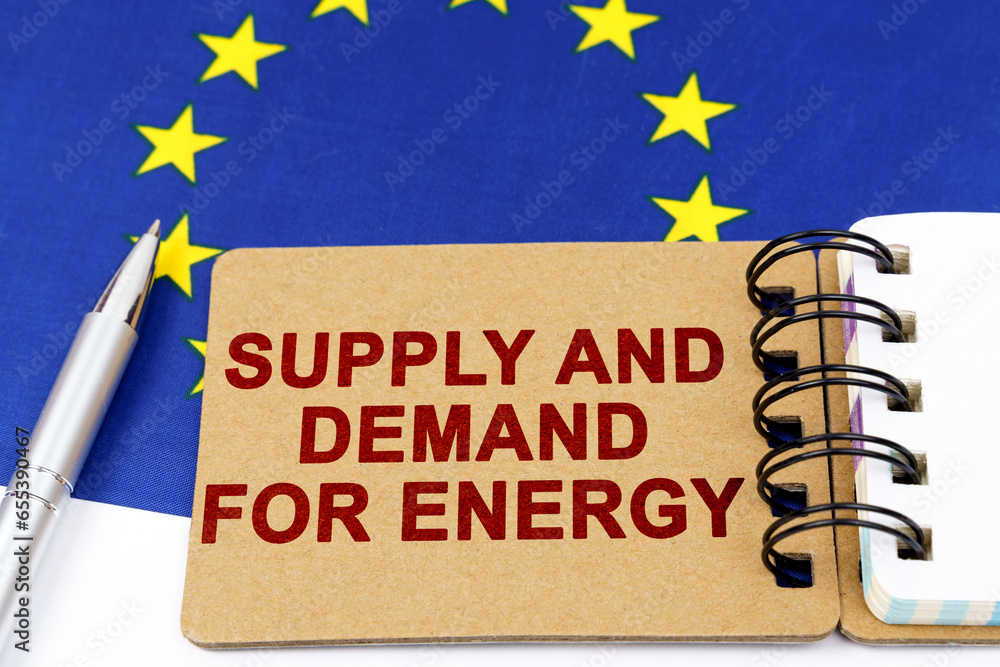 Obraz premium On the flag of the European Union lies a pen and a notepad with the inscription - supply and demand for energy