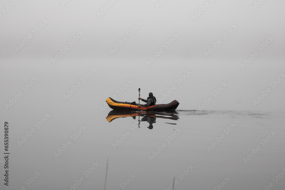 Fototapeta premium paddle boating in misty lake