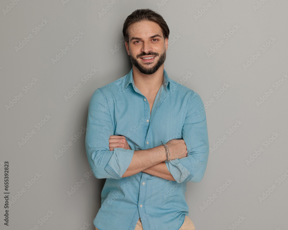 attractive young man crossing arms, smiling and posing attractive young man crossing arms, smiling and posing