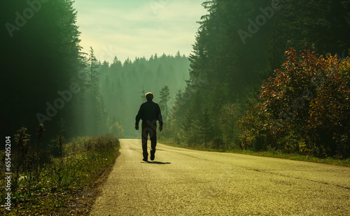 man walking on forest path sunrise