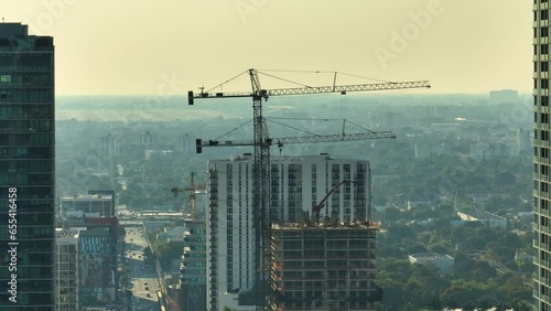 New construction site of developing residense in american urban area. Industrial tower lifting cranes in Miami, Florida. Concept of housing growth in the USA photo
