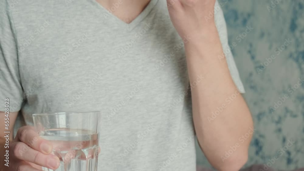 Man drinking capsule with omega 3, vitamin D with glass of water. Nutritional supplement with fish oil. Health support and treatment concept Man drinking capsule with omega 3, vitamin D with glass of water. Nutritional supplement with fish oil. Health support and treatment concept