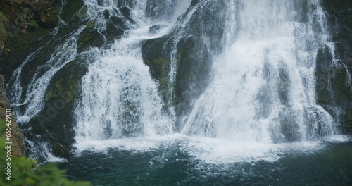 Mountain landscape with powerful waterfall in green coniferous forest. Full-flowing stream in Alps. Gollinger Wasserfall in Austria.