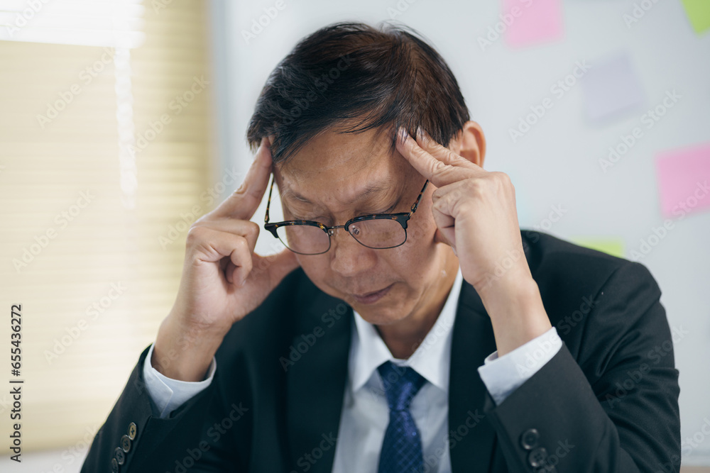 Asian business man serious focused or having a headache in office. Asian business man serious focused or having a headache in office.