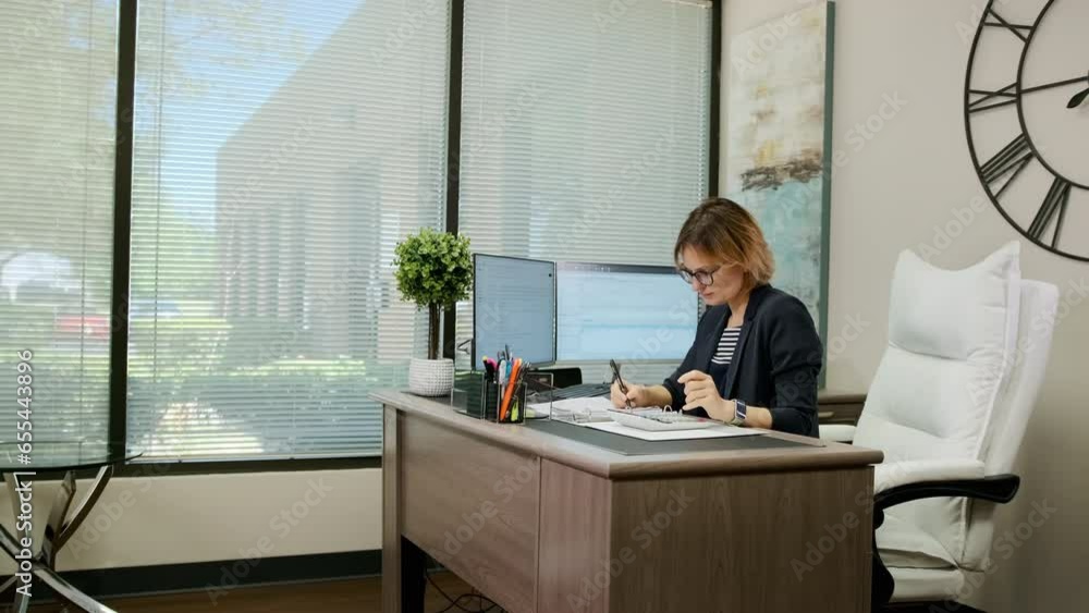 Woman sit at desk using computer, make data analysis, check statistics research, workday in office. Move camera footage Woman sit at desk using computer, make data analysis, check statistics research, workday in office. Move camera footage