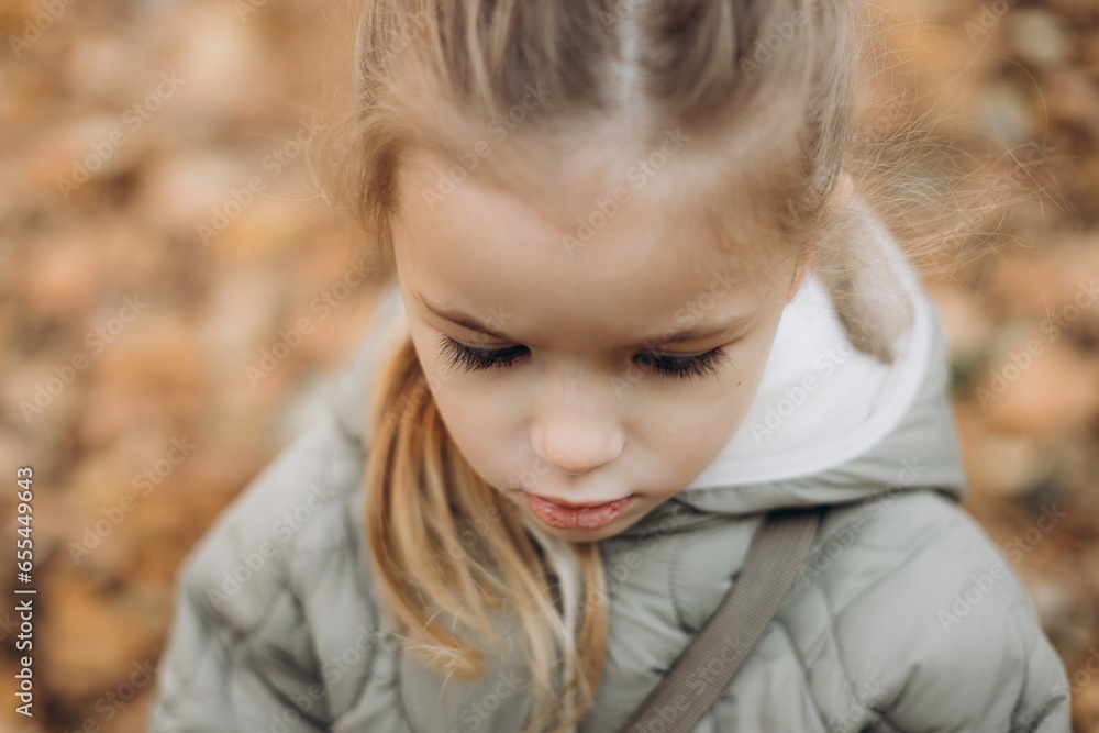 the face of a child playing in the yard in the evening on a cool autumn day