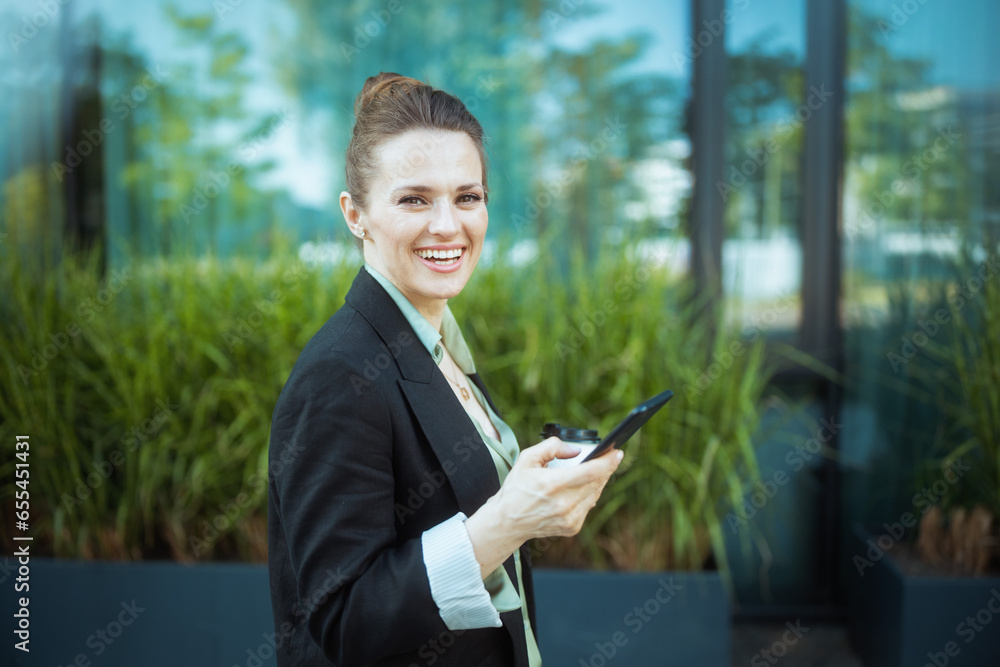 happy female worker in business district using smartphone happy female worker in business district using smartphone