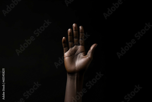 Generative AI illustration of crop anonymous African American person raising arm while fighting for social rights against black background photo