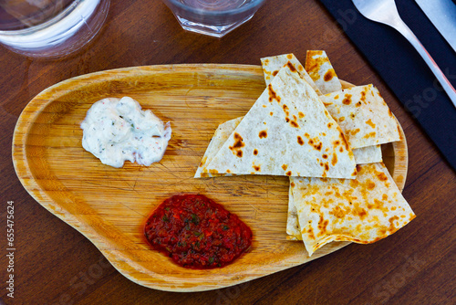 Traditional Arabian appetizer of toasted flatbread served with spicy tomato sauce and piquant garlic tomeya sauce photo