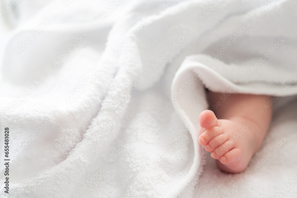 Tender tiptoe: newborn foot gently encased in white cover Tender tiptoe: newborn foot gently encased in white cover