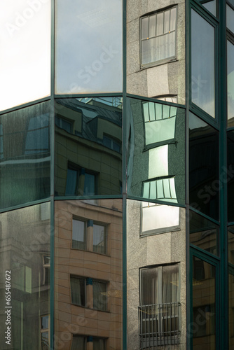 Old and Modern architecture concept. European architecture reflecting in the mirror glass facade of a modern building.