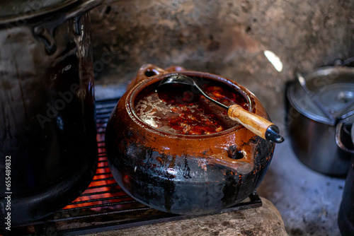 manos de mujer mexicana, sirviendo y cocinando birria en cocina rustica a la leña photo