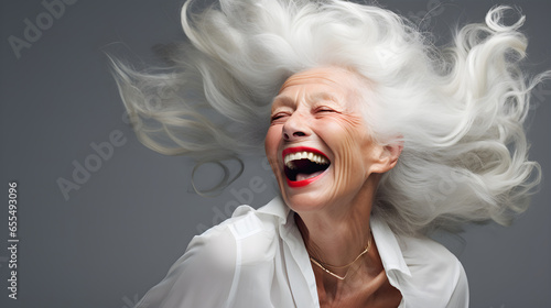 Beautiful elderly woman with long white hair, laughing and smiling, reflecting health and beauty with great skin and teeth. Centenarian