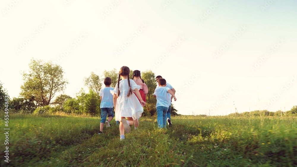 Happy little children with parents run together across lush meadow on vacation