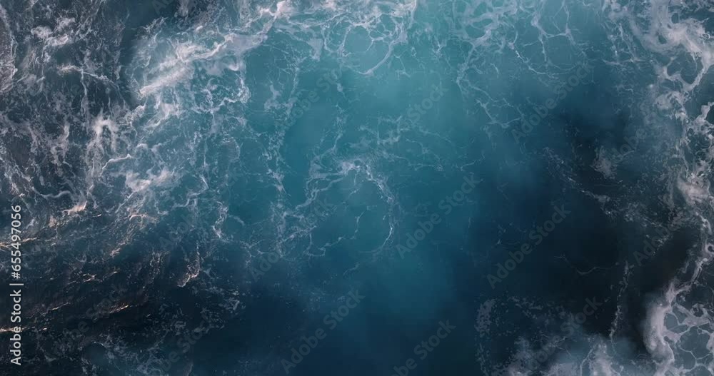 Beautiful texture of big power dark ocean waves with white wash. Aerial top view footage of fabulous sea tide on a stormy day. Drone filming breaking surf with foam. Big swell in Hawaii.