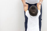 母親と手をつないでつかまり立ちする赤ちゃんの後ろ姿（男の子、生後9カ月、1歳、日本人）
